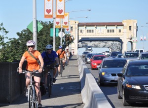 Riding across the Burrard Bridge in the cycling lane, protected from automobile traffic. During peak periods, between 500 to 800 cyclists cross the bridge every hour.  Photo courtesy of City of Vancouver 